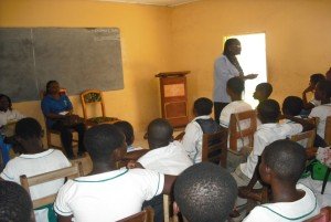 Rita (standing) makes a point on a recent SRH outreach to a Catholic school. Frances sits next to her