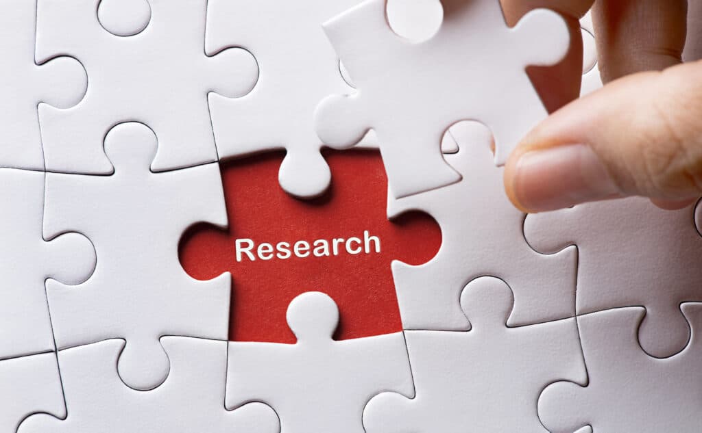 Puzzle with one piece going over the word Research