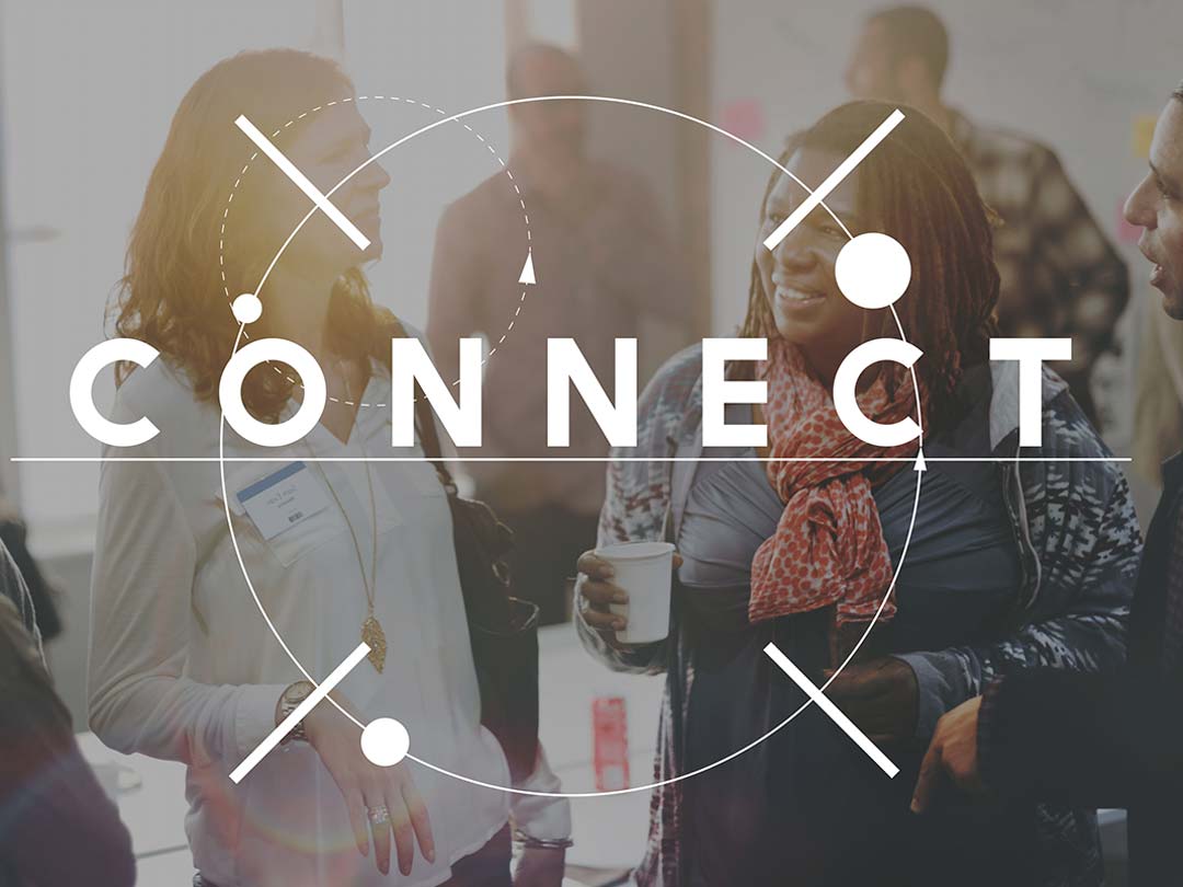 Diverse group of people talking at an event with overlaid text 'Connect'. 