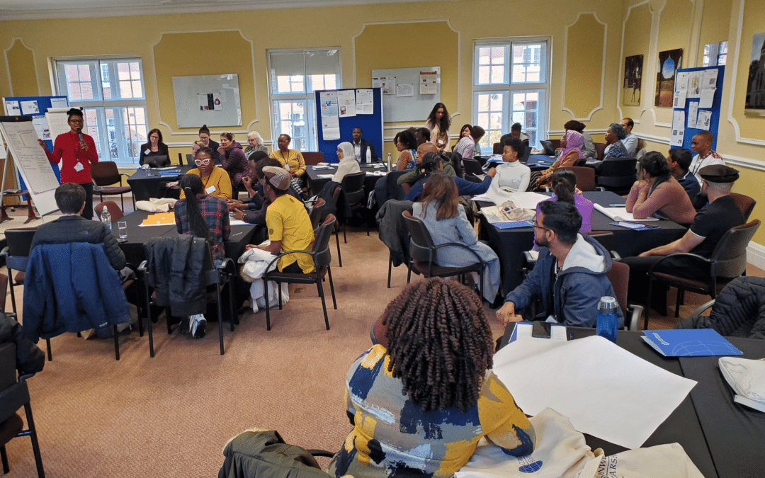 Scholars sitting at tables in groups.