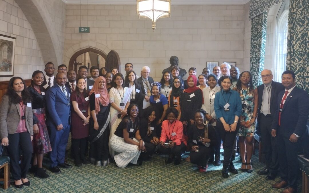 Group of Scholars and guests standing and smiling in Parliament.