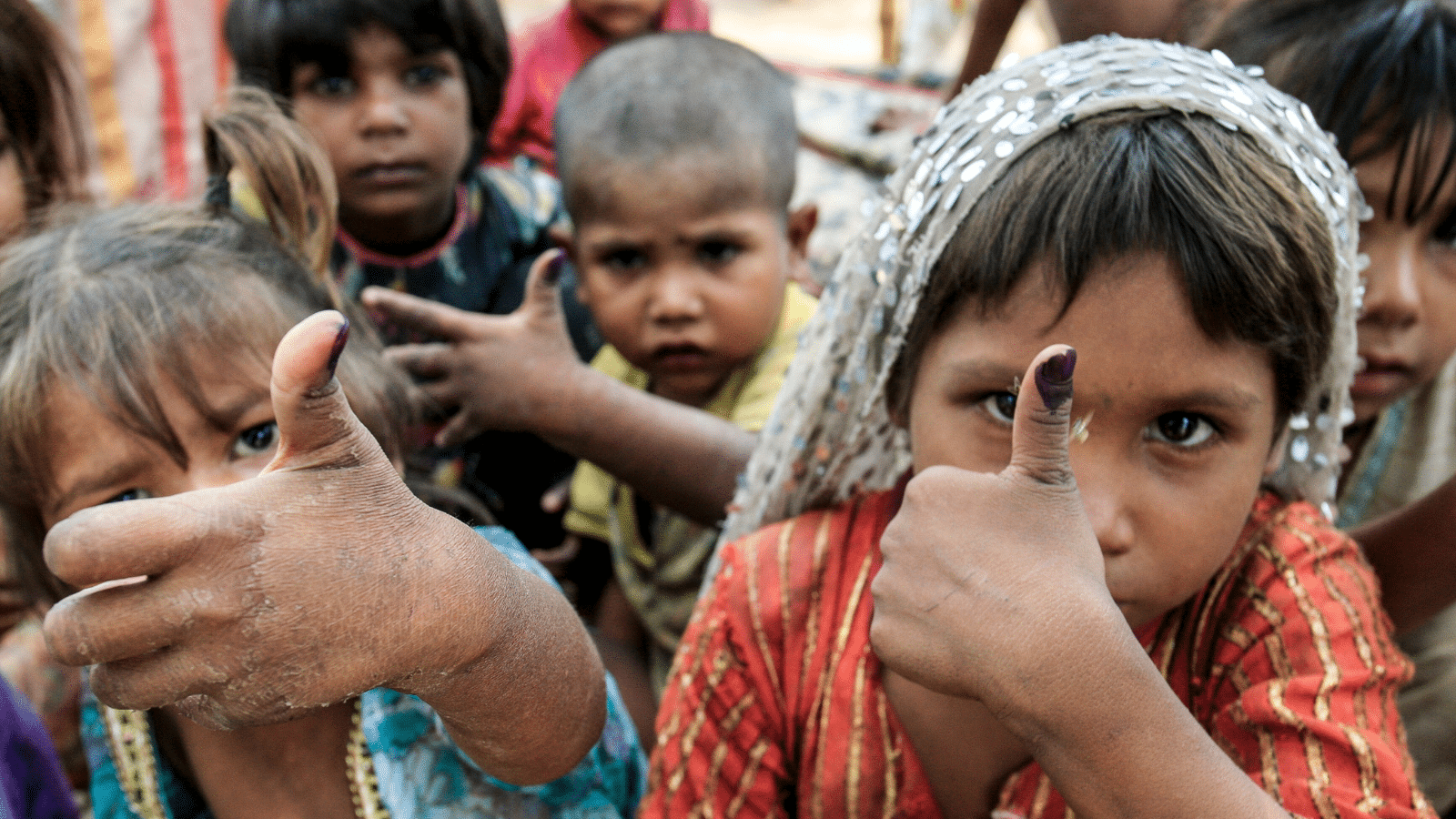 Pakistani children show fingers marked with ink to show they received vaccine