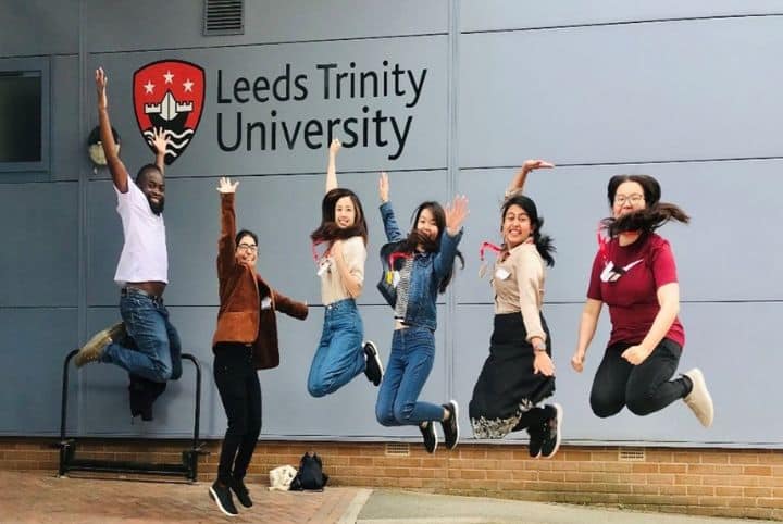 Team YOROKA jumping in front of Leeds Trinity University building.