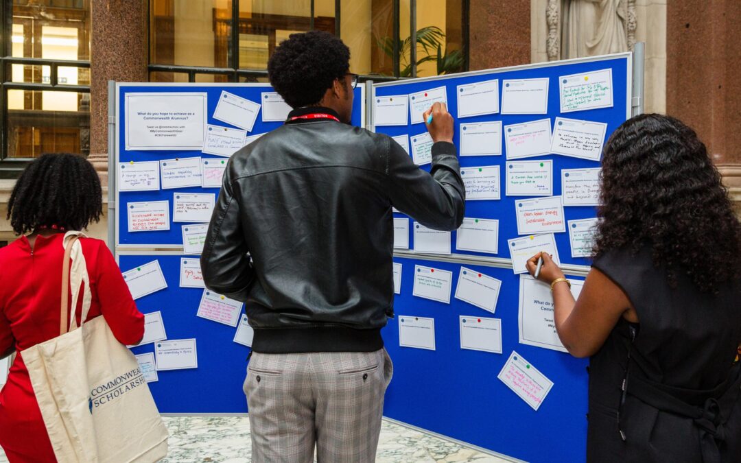 Three Scholars sharing feedback on a comment board at a CSC event.