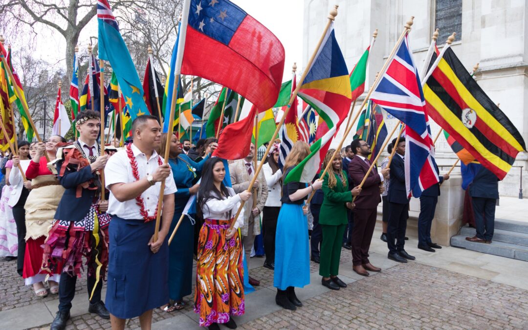 Group of people standing together and holding country flags for Commonwealth Day 2023.