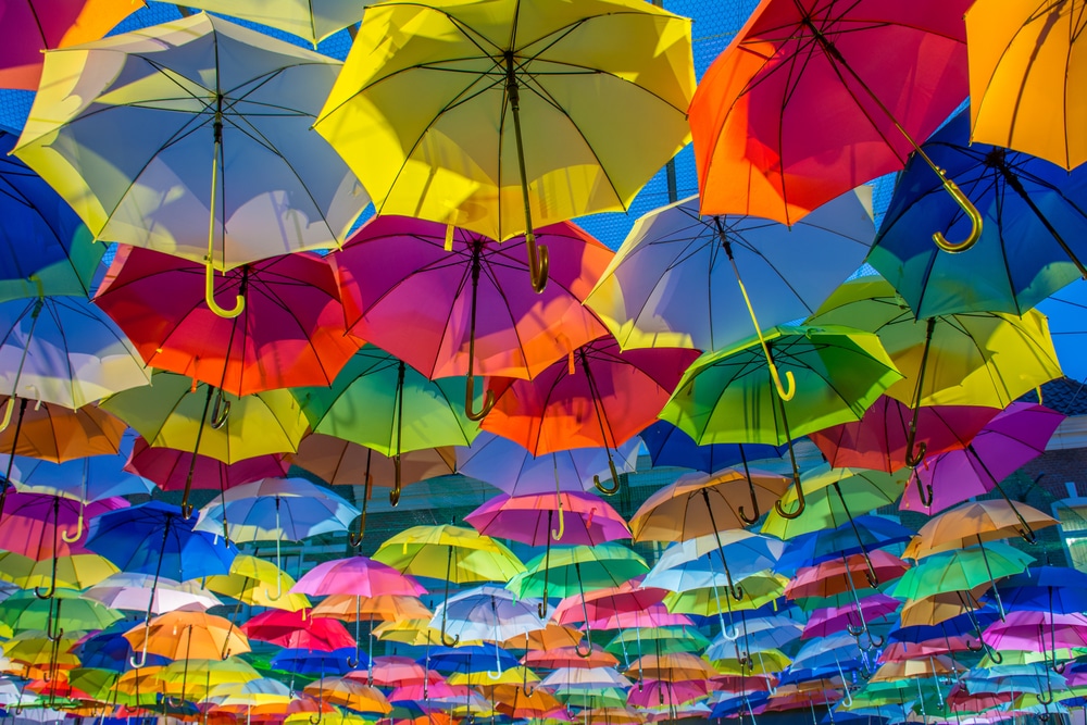 Large array of colourful umbrellas suspended in the air.