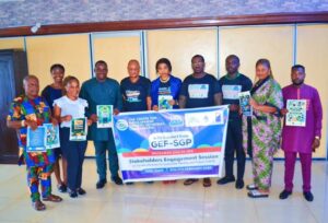Group of people standing holding a banner promoting a stakeholder engagement session on climate change