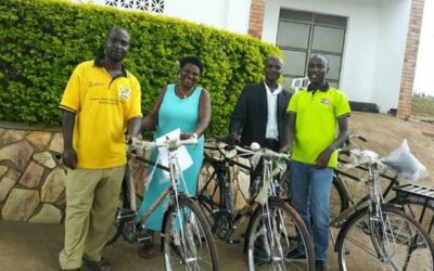 John Bosco (Right) handing over bicycles to community mobilisers.