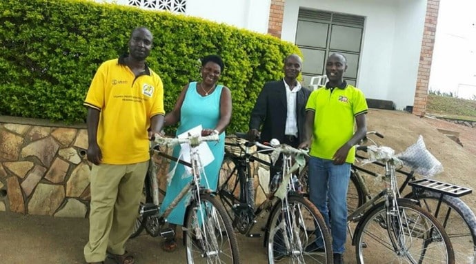 John Bosco (Right) handing over bicycles to community mobilisers.