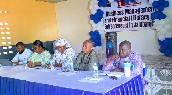 Speakers at the table with activity banner in the background
