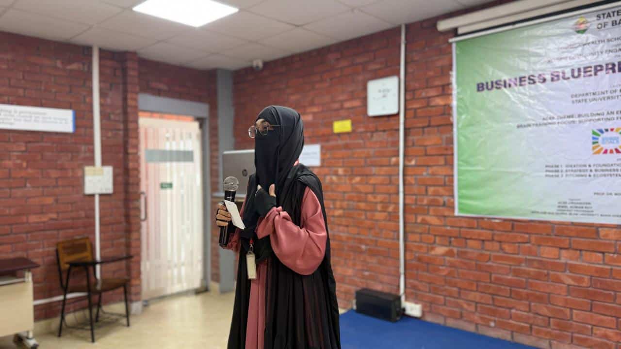 A woman with a mic giving a speech